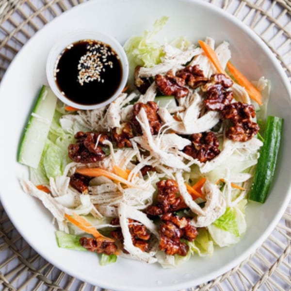 Howard Wang's Asian chicken salad with shredded chicken, candied walnuts, and a side of dressing.