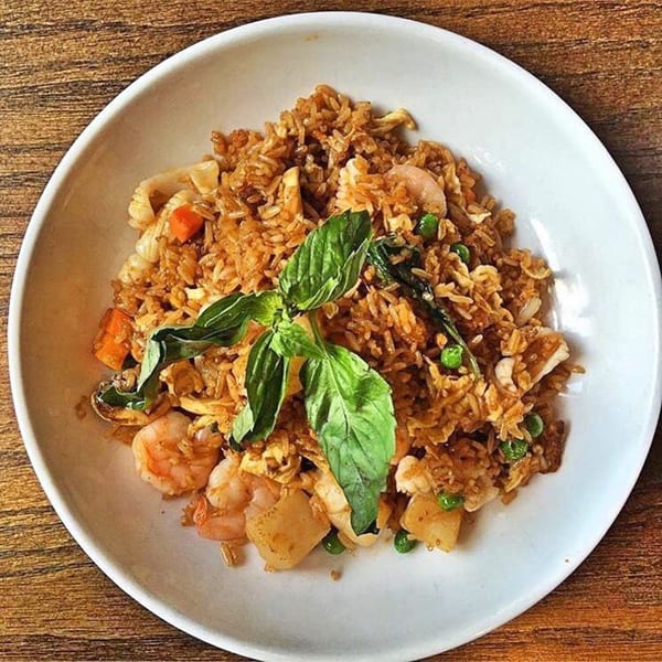 Howard Wang's Preston Hollow's fried rice with shrimp, vegetables, and basil in a white bowl.
